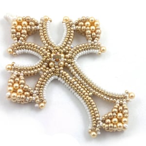 Può includere: Un ciondolo a forma di croce in perle dorate e bianche con un design dettagliato. La croce è realizzata con piccole perle rotonde disposte in un motivo intricato.