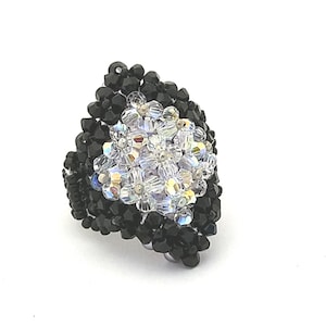 以下が含まれることがあります： 涙の形をした黒と透明なクリスタルビーズのリングです。