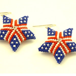 May include: A pair of star-shaped earrings with a red, white, and blue design. The earrings are made of beads and are hanging from silver hooks.