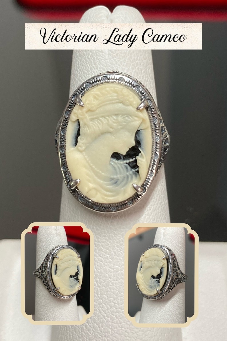 May include: A silver ring with a white cameo featuring a woman's profile. The cameo is set in a filigree design.