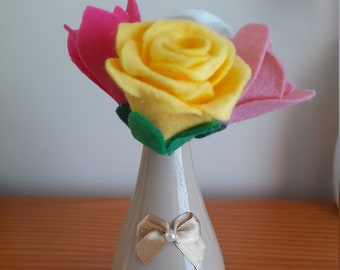 These 4 lovely Hand made felt flowers in a lovely 12cm pottery vase with decorative bow on.