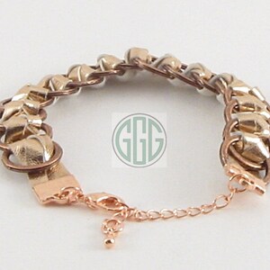 May include: A gold and silver chain bracelet with a lobster clasp closure.