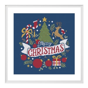 Op de afbeelding: Een kruissteekpatroon met een blauwe achtergrond, een kerstboom, een rendier, kerstballen en een banner met de tekst "Merry Christmas".