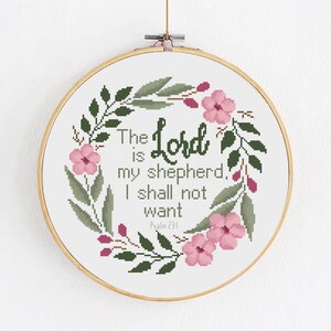 Puede incluir: Patrón de punto de cruz con una corona floral de flores rosas y hojas verdes. El texto dice "El Señor es mi pastor, nada me faltará, Salmo 23:1".