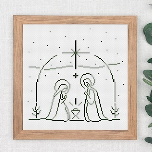 Könnte beinhalten: Ein schwarz-weißes Kreuzstichmuster der Weihnachtsgeschichte mit Maria und Josef, die neben einer Krippe mit einem Stern über ihnen stehen.