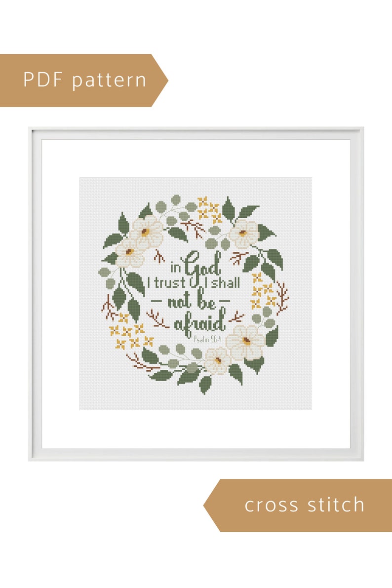 May include: Cross stitch pattern framed in white. The design features a floral wreath with white flowers, green leaves, and yellow accents. The text reads "in God I trust I shall not be afraid" with "Psalm 56:4" below. The words "PDF pattern" and "cross stitch" are also present.