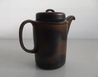 Puede incluir: Una cafetera de cerámica marrón con un esmalte moteado y una tapa. La cafetera tiene un asa y un pico.