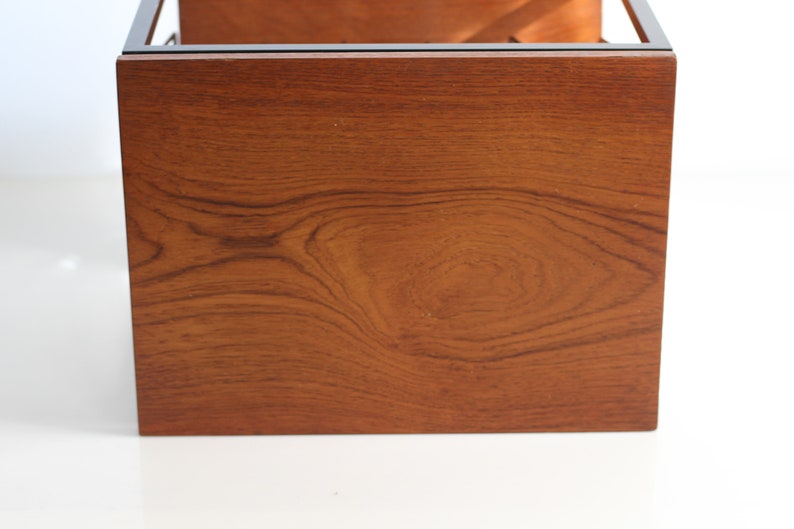 Puede incluir: Primer plano de la parte inferior de una mesa de caf&eacute; de madera con veta de madera marr&oacute;n oscuro. La mesa tiene un marco de metal negro.