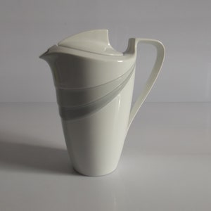 May include: White ceramic jug with a grey stripe design and a lid.