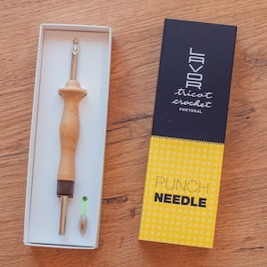 Op de afbeelding: Een houten priknaald met een metalen punt, verpakt in een witte doos met een geel en zwart etiket met de tekst "Lavor tricot crochet Portugal Punch Needle".