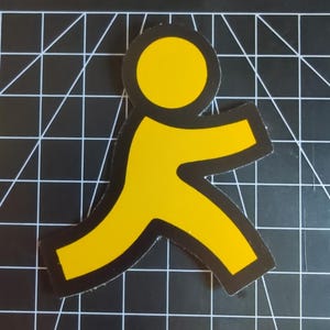 Pode incluir: Um autocolante amarelo e preto com o icónico logótipo da pessoa a correr. O logótipo é uma figura estilizada com os braços e pernas estendidos, sobre um fundo preto. O autocolante tem uma borda preta.