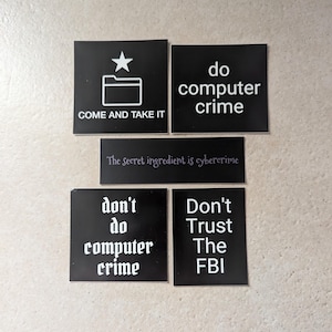 Może przedstawiać: Pięć czarno-białych naklejek z różnymi napisami. Pierwsza naklejka ma białą gwiazdę i ikonę folderu z tekstem "COME AND TAKE IT". Druga naklejka ma napis "do computer crime". Trzecia naklejka ma napis "The secret ingredient is cybercrime". Czwarta naklejka ma napis "don't do computer crime". Piąta naklejka ma napis "Don't Trust The FBI".
