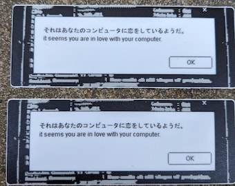 May include: Two black and white stickers with a computer error message that reads "It seems you are in love with your computer." in English and Japanese. The message is displayed in a white box with a black border and an "OK" button.
