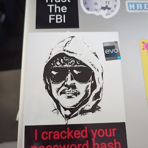 May include: A black and white sticker with a hooded figure wearing sunglasses and a mustache. The sticker has the text "I cracked your password hash" in red letters on a black background.