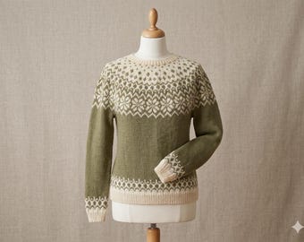 May include: A green and cream-colored sweater with a patterned yoke and cuffs. The sweater is displayed on a mannequin. The yoke and cuffs feature a repeating geometric design. The body of the sweater is a solid green color.