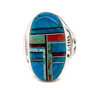 May include: Silver ring with a large oval turquoise and multi-coloured stone inlay. The inlay features a geometric design with shades of blue, red, and green. The ring has a detailed silver band.