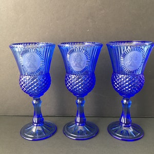 May include: Set of three cobalt blue glass goblets with a diamond pattern and a raised cameo design.