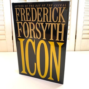 May include: A black hardcover book with gold lettering. The title is "ICON" by Frederick Forsyth, author of "The Day of the Jackal".