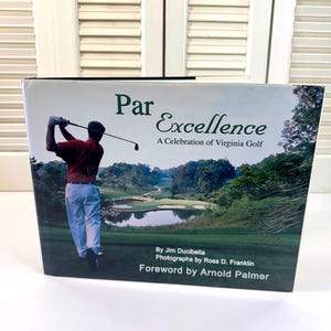 May include: A book titled "Par Excellence: A Celebration of Virginia Golf" features a golfer in action on the cover. The cover also displays a golf course scene and the names of the author, photographer, and the foreword writer.
