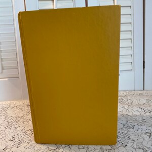 May include: A solid yellow box with a smooth, flat surface. The box is made of a sturdy material and has a simple, modern design.