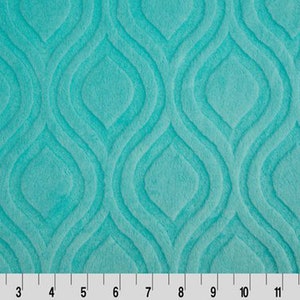 May include: Teal blue fabric with a raised, embossed pattern of repeating teardrop shapes.