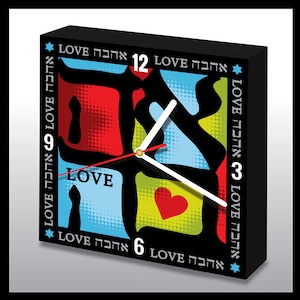 May include: A black square clock with a colorful design featuring the Hebrew word for love, "אהבה", repeated around the clock face. The clock hands are red and white, and the clock face is divided into four sections, each with a different color and pattern. The clock face also features a red heart.