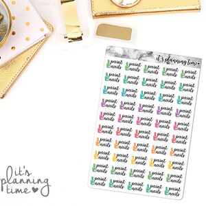 May include: A sheet of planner stickers featuring the words "paint nails" in a variety of colours, including green, blue, pink, and orange. The stickers are on a white background, with the text "it's planning time" in the upper right and lower left corners.