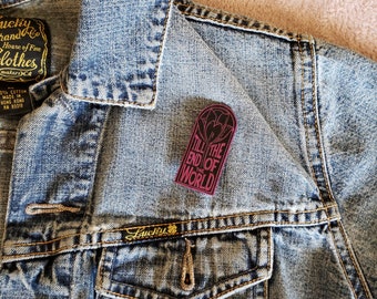 May include: A dark denim jacket with a patch that says "Till the end of the world" in a gothic font. The patch is burgundy with gold lettering and a heart design.