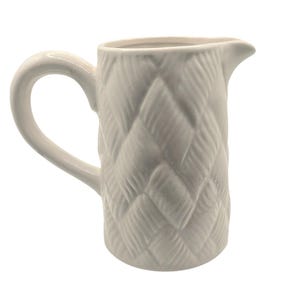 May include: A set of three ceramic mugs with a speckled, matte finish. Each mug features a different color: light blue, cream, and gray. The mugs have a simple, modern design with a rounded shape and a comfortable handle.