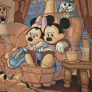 May include: A woven tapestry featuring Mickey and Minnie Mouse sitting together on a brown armchair, with Pluto sleeping on the floor. A snowman is visible through a window in the background. The text Walt Disney World is printed at the bottom.