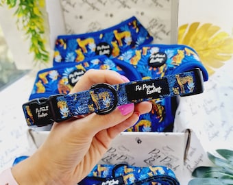 May include: A blue and black dog collar with a jungle print featuring a cheetah, leaves, and the text "Pet Pouch Boutique".