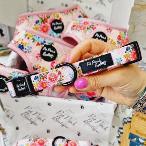 Può includere: Un collare per cani floreale rosa con accessori neri e il testo "Pet Pooch Boutique".