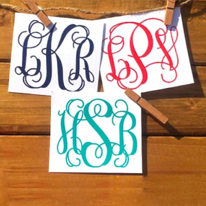May include: Three white cards with different monogram designs. The first card has a navy blue monogram with the letters "KR". The second card has a red monogram with the letters "PS". The third card has a teal monogram with the letters "HSB".