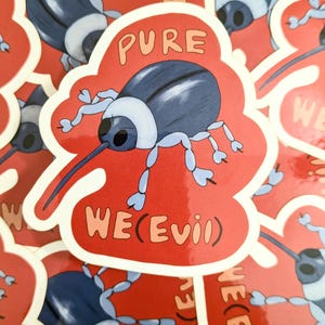 May include: A sticker with a cartoon beetle design. The beetle is blue with light blue legs and a long snout. The sticker has the words "PURE WE(EVIL)" in orange and white on a red background.