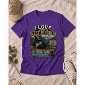 Puede incluir: Una camiseta morada con un gr&aacute;fico de un oso con gafas de sol y sombrero, sentado en una silla con una taza. El texto dice: I LOVE LIVING IN WEST VIRGINIA, WHERE THE ROADS ARE WINDING, THE PEOPLE ARE KIND, AND THE ONLY TRAFFIC JAM IS BEHIND A SLOW TRACTOR. Y'ALL WOULDN'T UNDERSTAND.