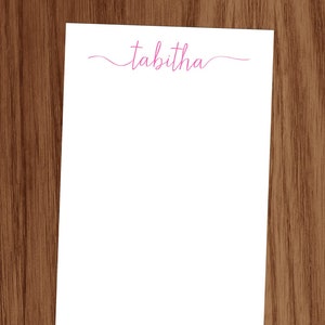 May include: White notepad with the name "tabitha" written in pink cursive at the top.