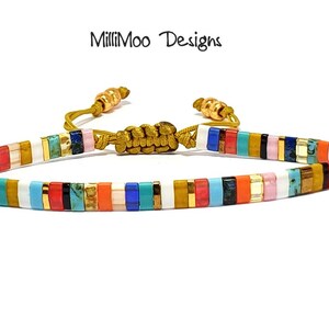 May include: Multicolored beaded bracelet with gold accents and a sliding knot closure. The bracelet features a variety of colors, including white, blue, red, orange, yellow, and green.