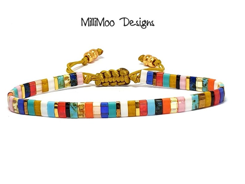 May include: Multicolored beaded bracelet with gold accents and a sliding knot closure. The bracelet features a variety of colors, including white, blue, red, orange, yellow, and green.