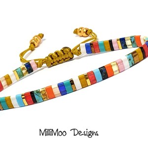 May include: Multicolored beaded bracelet with a gold cord closure. The bracelet features a variety of colors, including white, blue, red, orange, yellow, and green. The beads are arranged in a striped pattern.