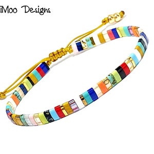 May include: Multicoloured beaded bracelet with a gold cord fastening. The beads are arranged in a striped pattern with colours including red, orange, yellow, green, blue, purple, and black.