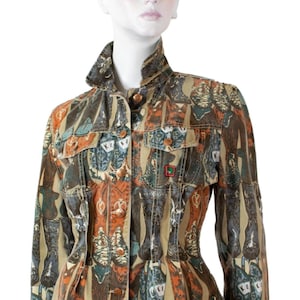 May include: A long-sleeve jacket featuring a repeating print of cowboy boots in shades of brown, orange, and teal. The jacket has a structured collar, a front button closure with metallic buttons, and two chest pockets with buttoned flaps.