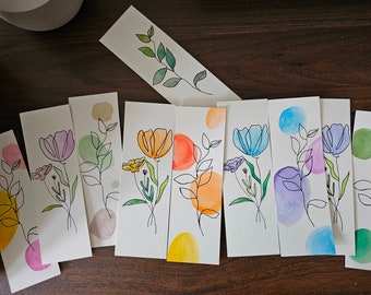 May include: Set of eight watercolor bookmarks featuring simple line drawings of flowers with colorful watercolor backgrounds. Each bookmark is approximately 10.5 cm by 5 cm.