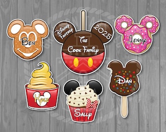 May include: Set of 10 Disney-themed Mickey Mouse head-shaped food stickers. The stickers feature various food items like a cupcake, ice cream, a chocolate-covered ice cream bar, and a Mickey Mouse apple. Each sticker has a different name on it, including Ben, Jenny, Dan, Kyle, and Sally. The stickers also include the text "Disney Fantasy" and "The Cook Family 2023".