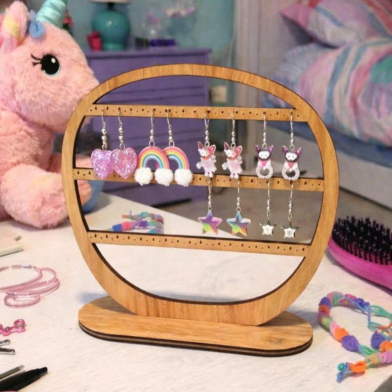 May include: A wooden earring display stand with a circular design, holding various earrings. The earrings include heart-shaped, rainbow, and star designs, along with cute animal figures. The stand is made of light-colored wood.