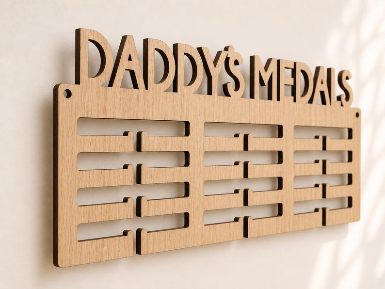 Pu&ograve; includere: Espositore di medaglie in legno con le parole "DADDY'S MEDALS" intagliate nella parte superiore. L'espositore ha pi&ugrave; fessure orizzontali per appendere le medaglie. Il legno &egrave; di colore marrone chiaro.