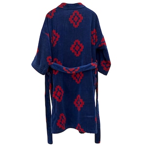 May include: A navy blue terry cloth robe with a red geometric pattern. The robe has a shawl collar, short sleeves, and a matching belt. The pattern is repeated across the robe, including the belt.