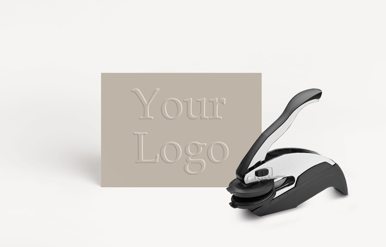 May include: A silver and black self-inking stamp with a handle. The stamp is designed to imprint the text "Your Logo" on paper.