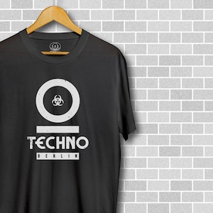 May include: Black t-shirt with a white circle containing a biohazard symbol and the text "TECHNO BERLIN" underneath.