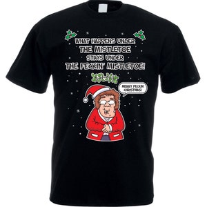 May include: Black t-shirt featuring a cartoon illustration of a woman wearing a Santa hat and red jacket. The text on the shirt reads "What happens under the mistletoe stays under the feckin' mistletoe!" and "Merry feckin Christmas!"