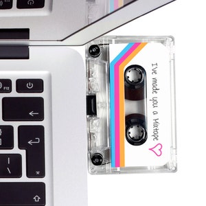 May include: A clear plastic cassette tape with a white label. The label has a rainbow design and the text "I've made you a mixtape" with a pink heart.